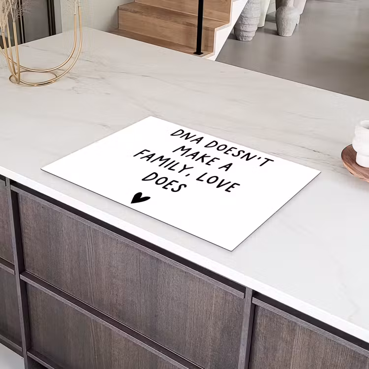 Engelse quote "DNA doesn't make a family, love does" met een hartje op een witte achtergrond Inductie beschermer vinyl 3mm klein -sfeer8